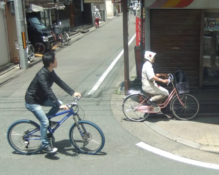 a woman on a bike with her friend riding down the road