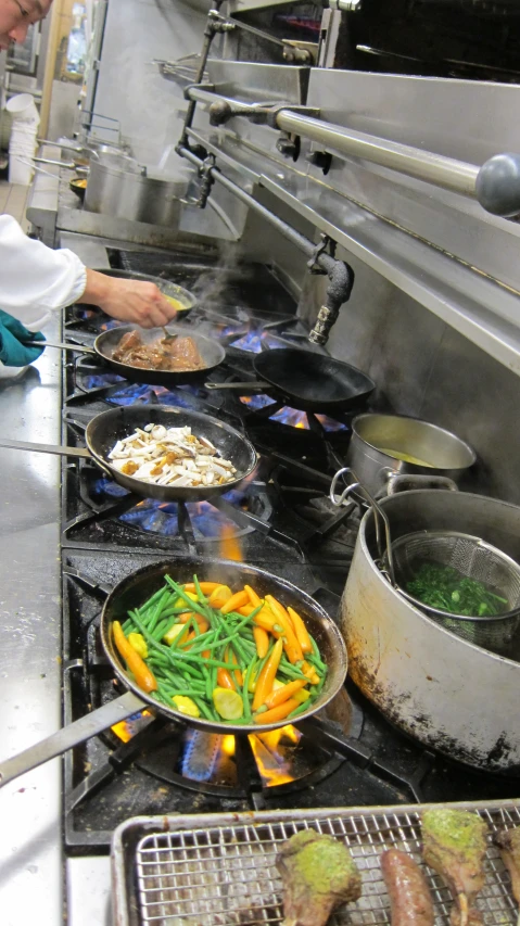 a large group of food cooking in pots on a stove