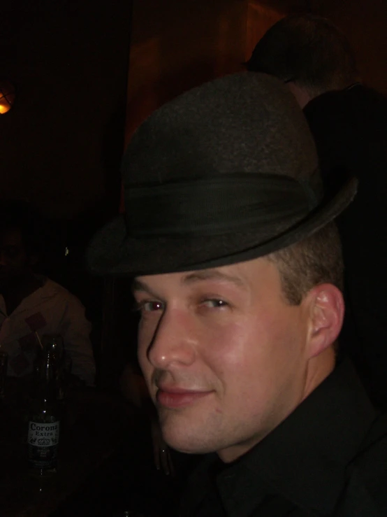 a man wearing a suit and hat posing for the camera