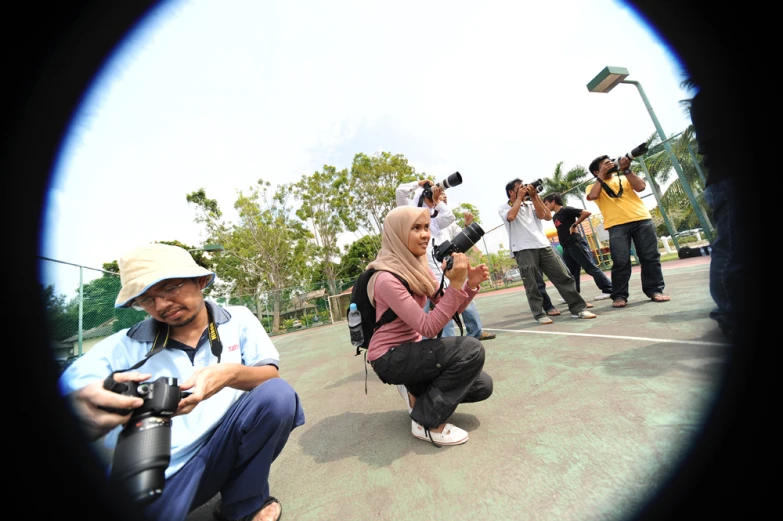 a group of people sitting down and taking pictures with cameras