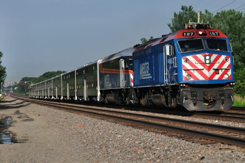 an electric train engine carrying carts down tracks