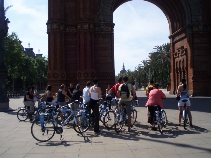 several people standing by bikes on the sidewalk