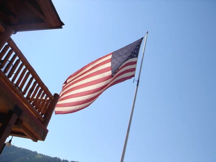 an american flag flies high above a wooden building