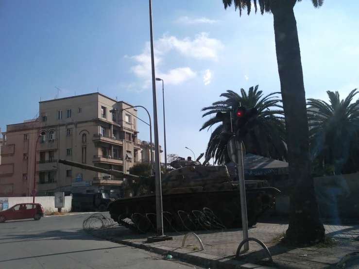 a view of the back of an old tank, with other vehicles in the background