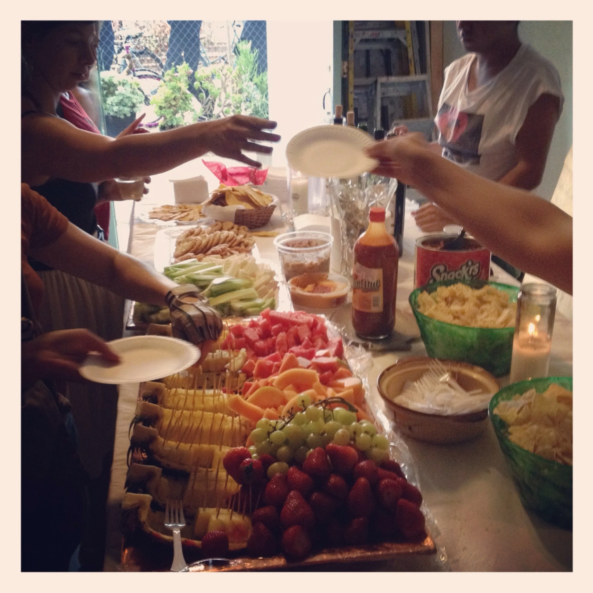 many people are getting food and drinks on the table