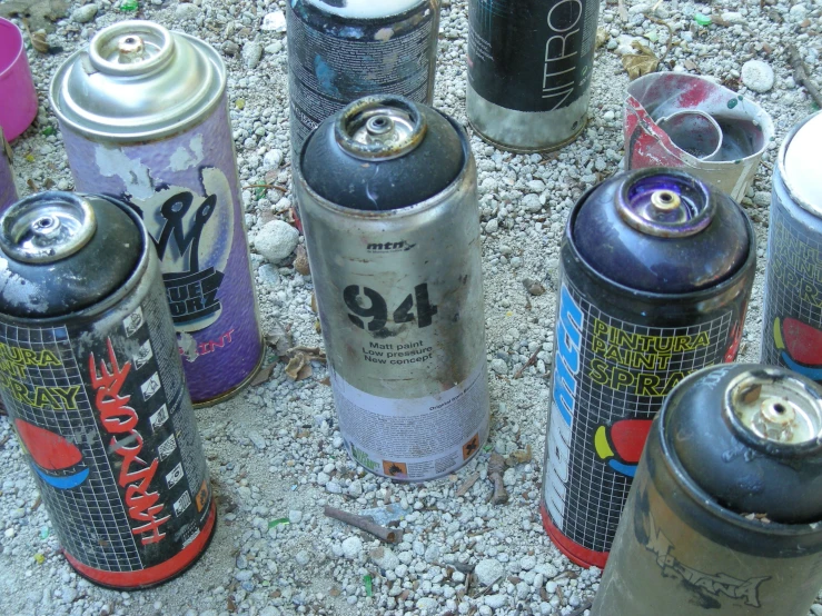 several cans are lined up against the ground