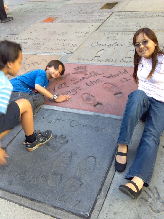 a group of s sitting on the side walk