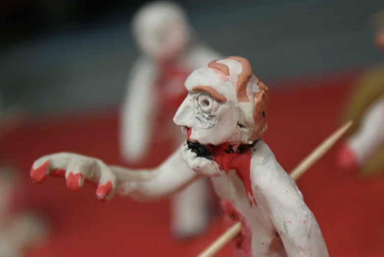 some miniature zombies holding sticks are dressed in zombie clothes