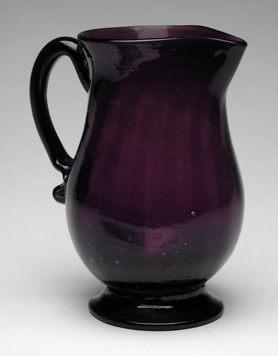 a dark purple ceramic pitcher that is black