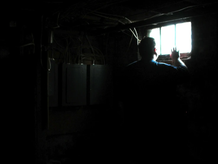 a person standing in a darkened room with windows