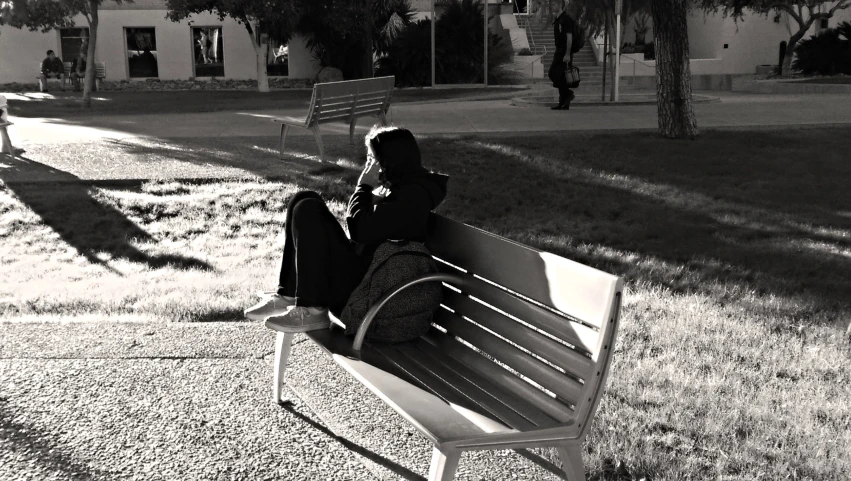 a person sitting on a bench in the sun