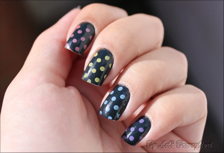 a woman with a colorful nail polish decorated with dots