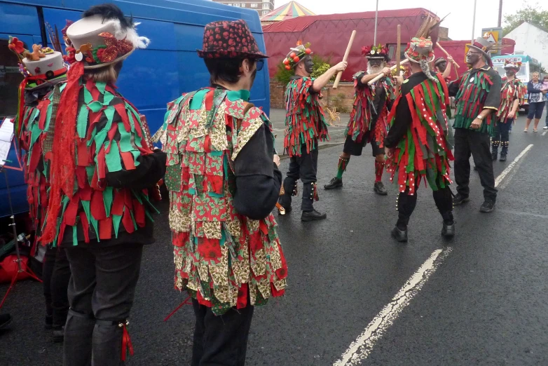 a band of men with costumes are standing in the street