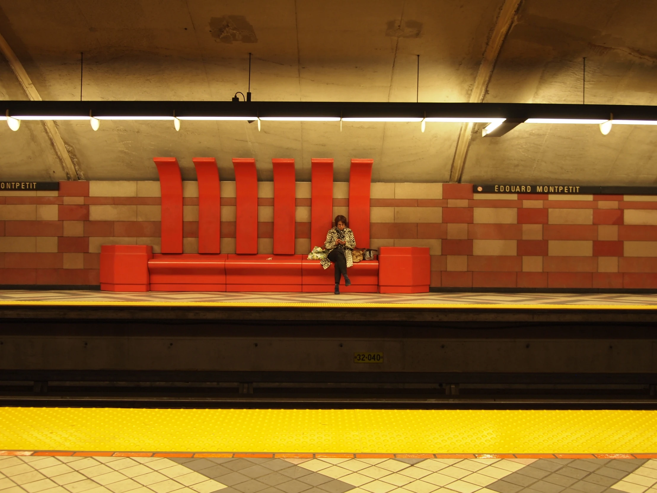 a woman sitting alone on the train platform