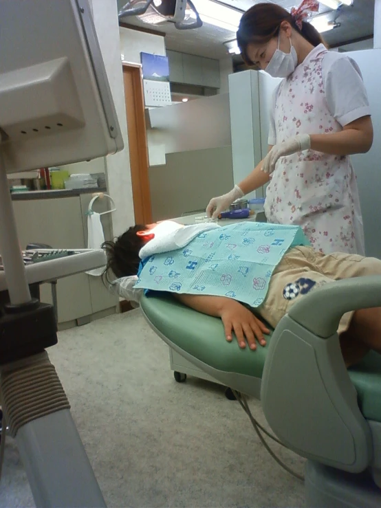 a  laying on the dentist chair with medical equipment