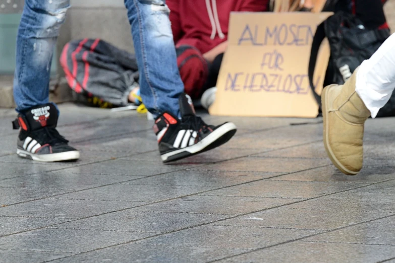 several people with shoes standing next to each other on a cement surface