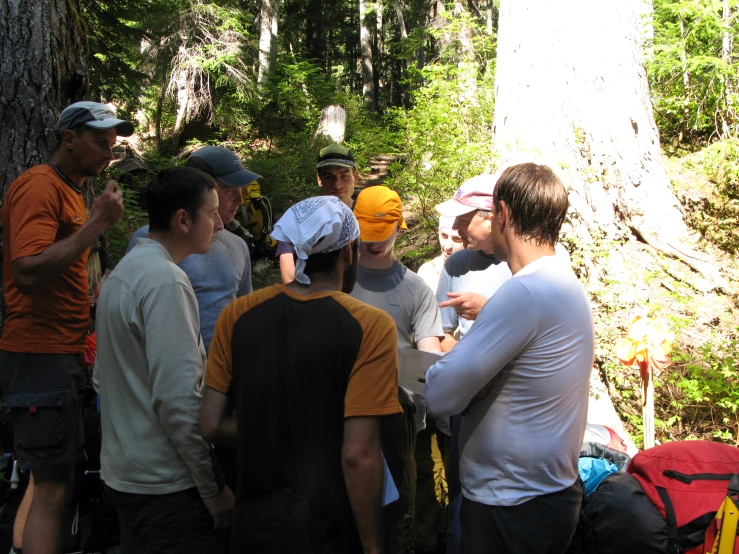 people standing around each other in the woods