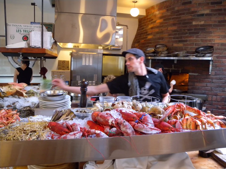 a man standing behind a buffet covered in seafood