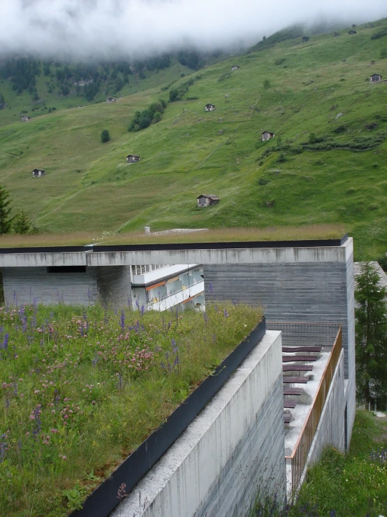 an aerial view of a green roof on a concrete structure with a farm scene in the background