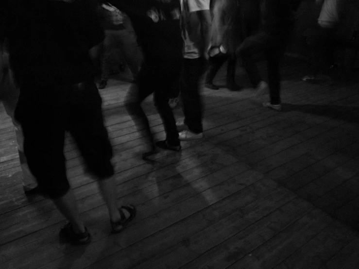people dance together on a wooden deck at night