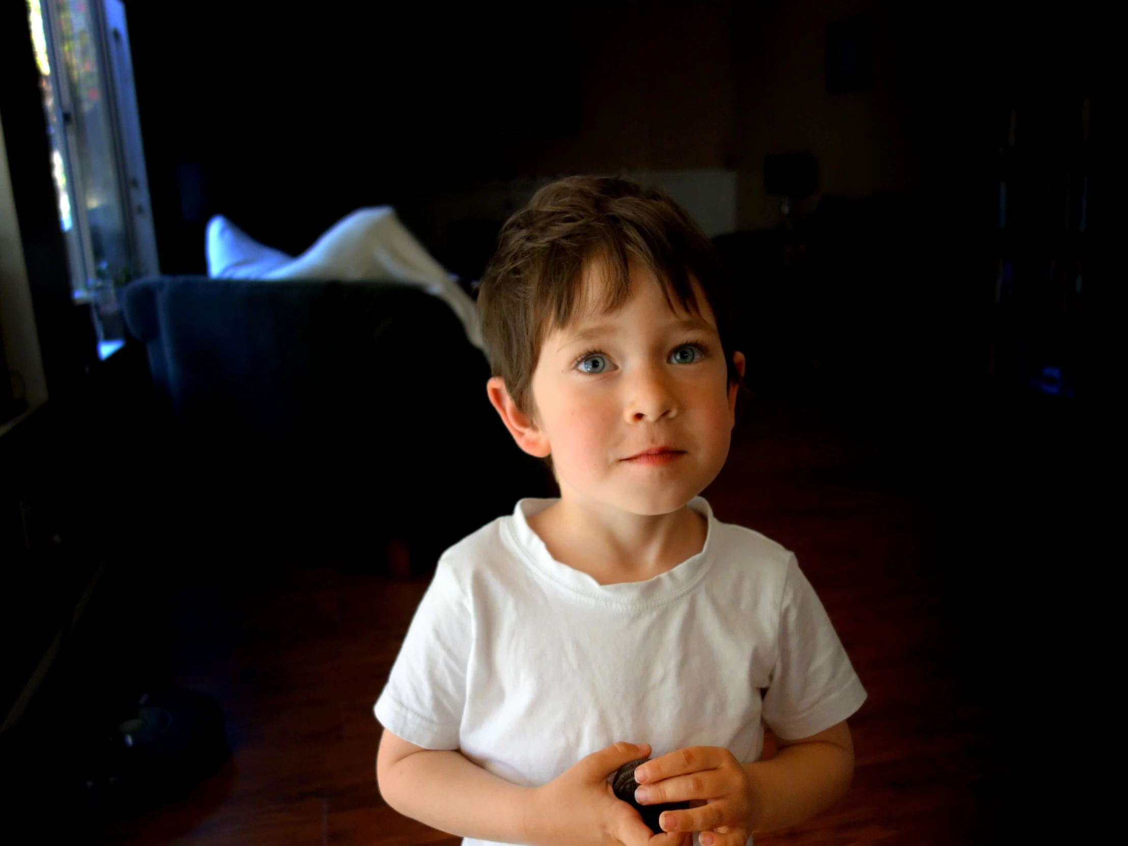 a  standing on a hardwood floor with his hands clasped