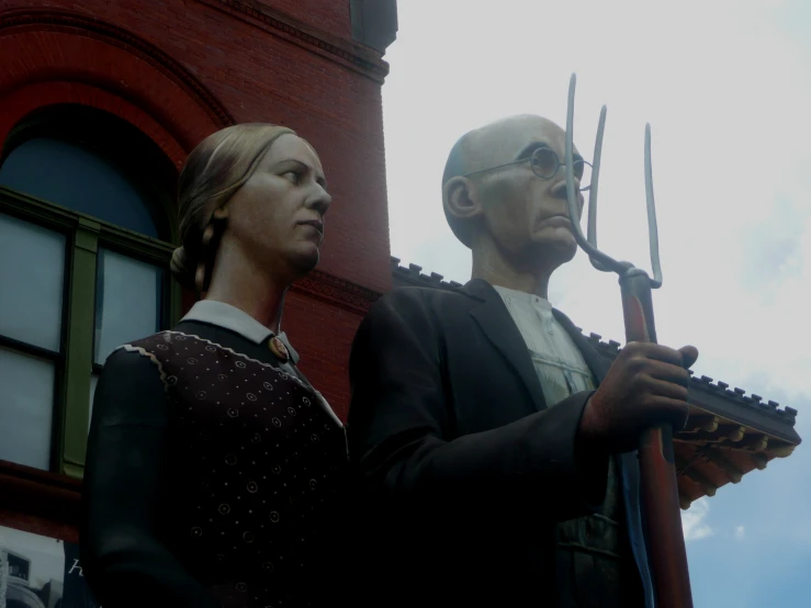 two statues of people are on display on the street