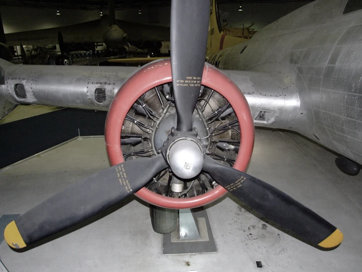 a propeller on top of an airplane with red and yellow wheels