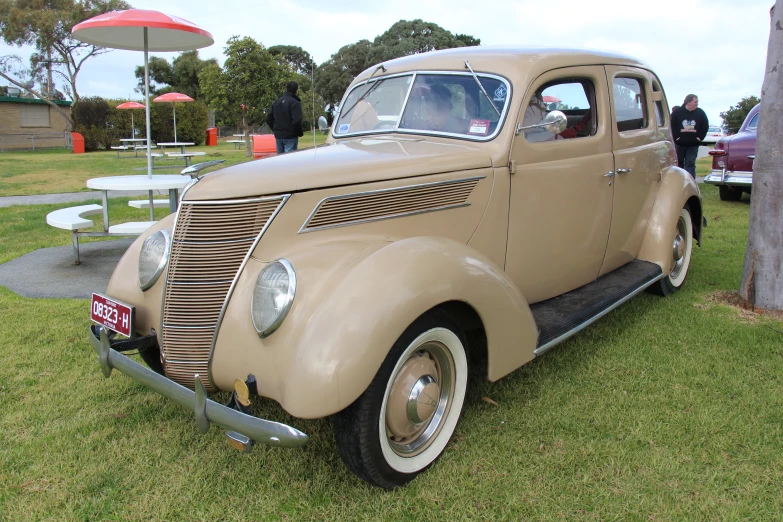 an antique beige truck on display at a car show