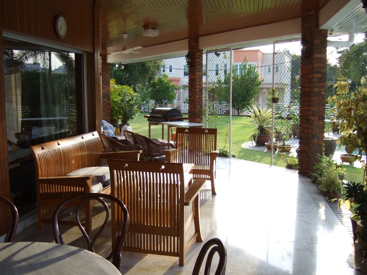 a wooden patio with wood table sitting under a cover