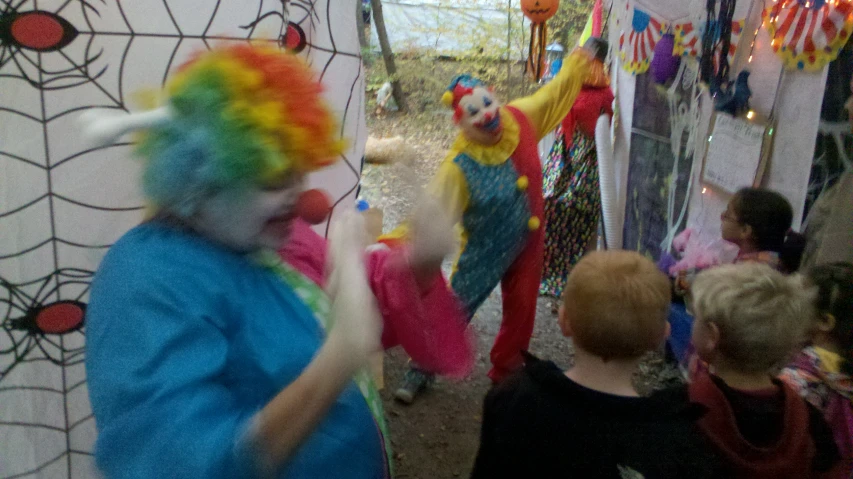 a woman dressed as clown juggling at a birthday party