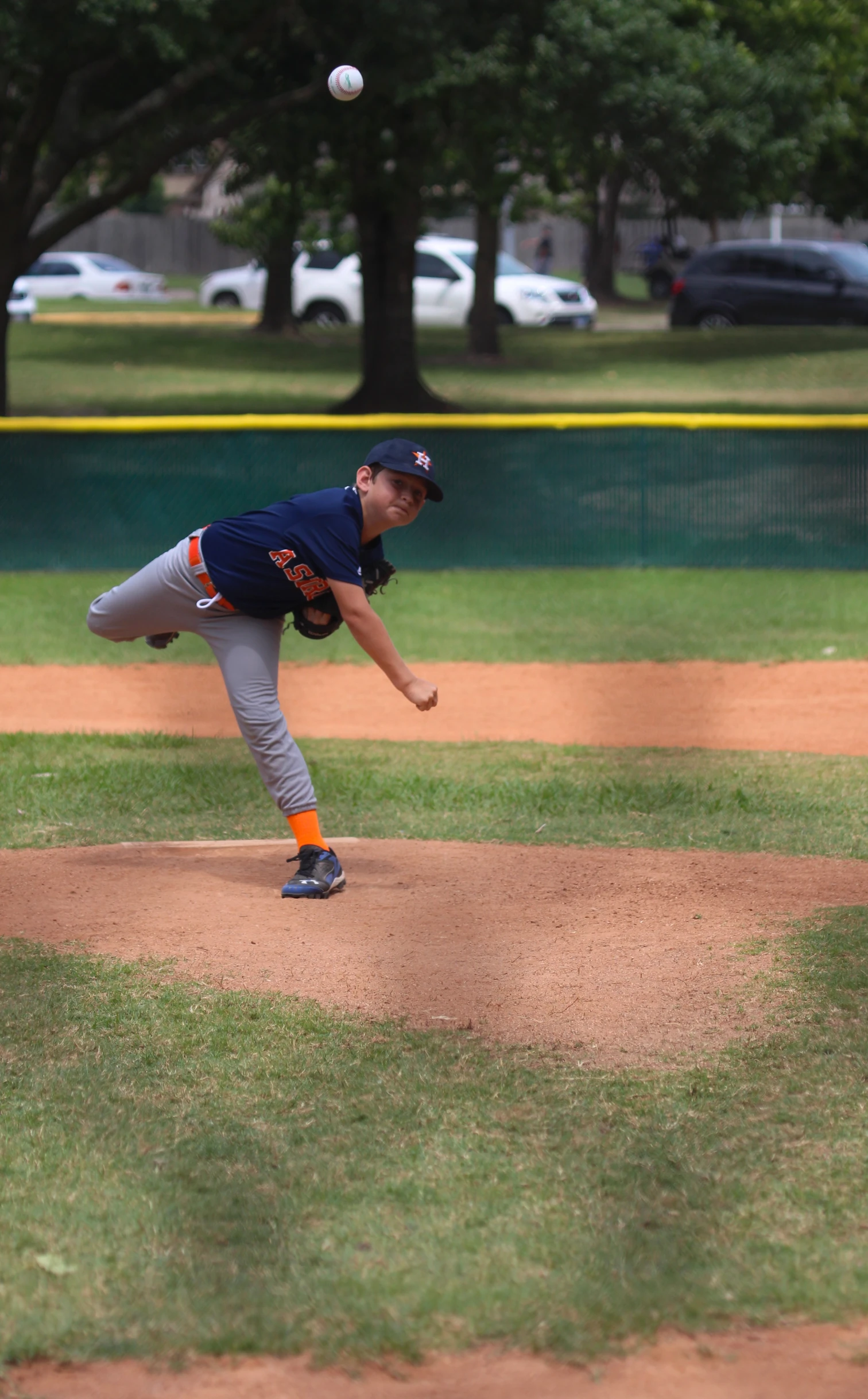 a baseball player pitching a ball on top of a field