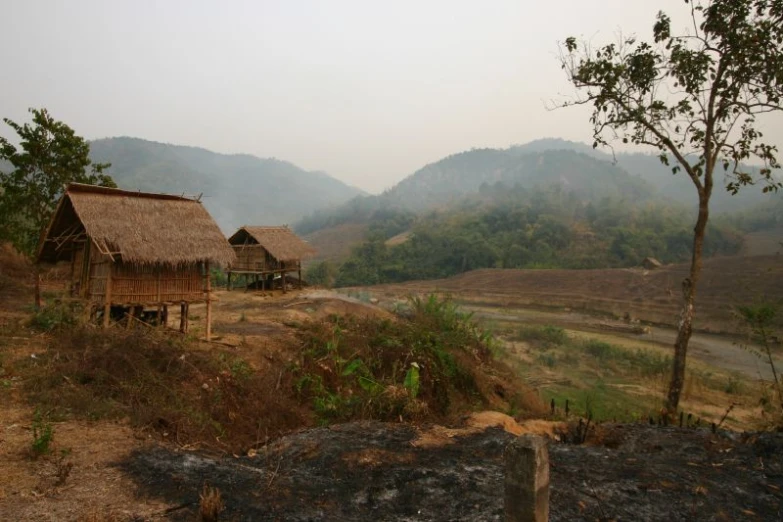 a couple of house sitting on top of a dirt field