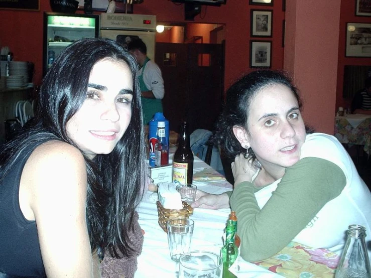 two women at a restaurant sitting down smiling