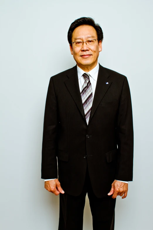 a man in suit and tie standing up for a picture