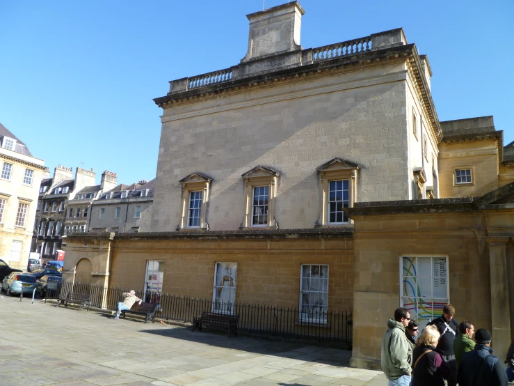 several people line up in front of a large building