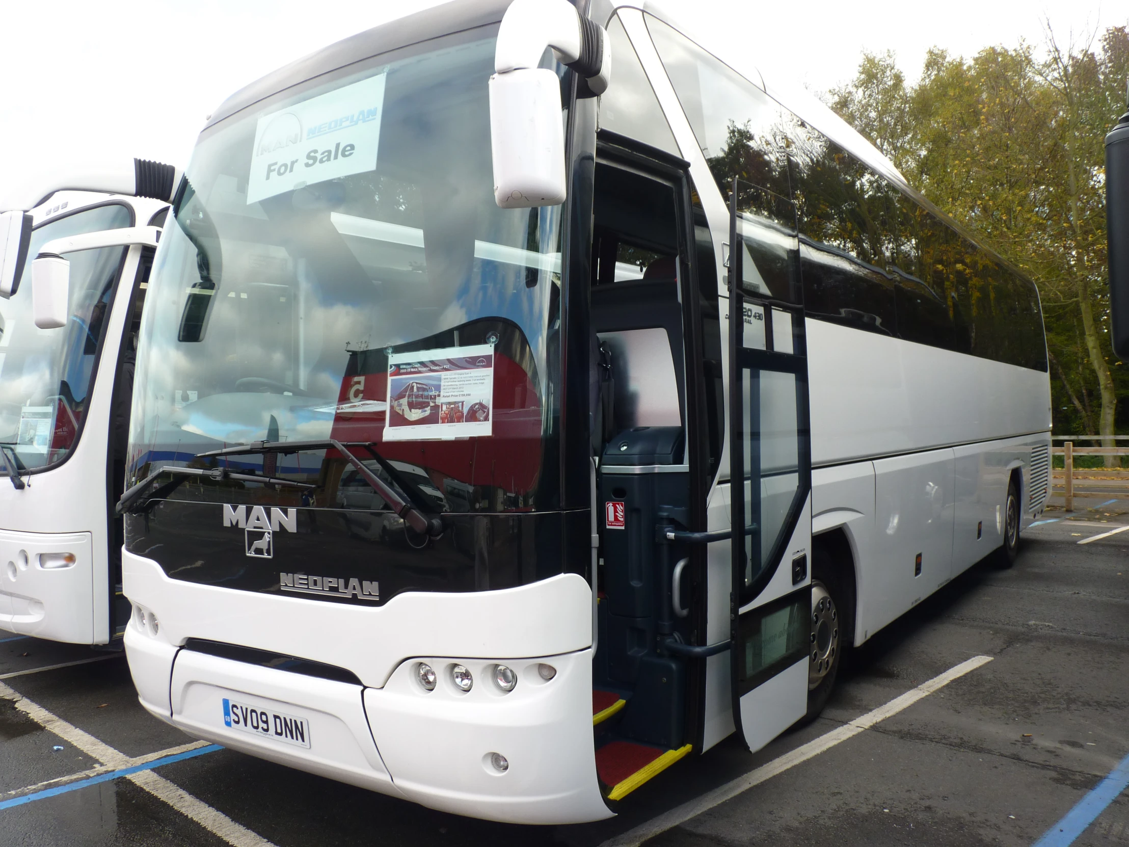 two white tour buses sitting side by side