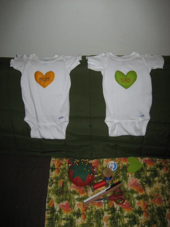 two ones with heart shaped patches on them sit next to a scissors and a flowery napkin