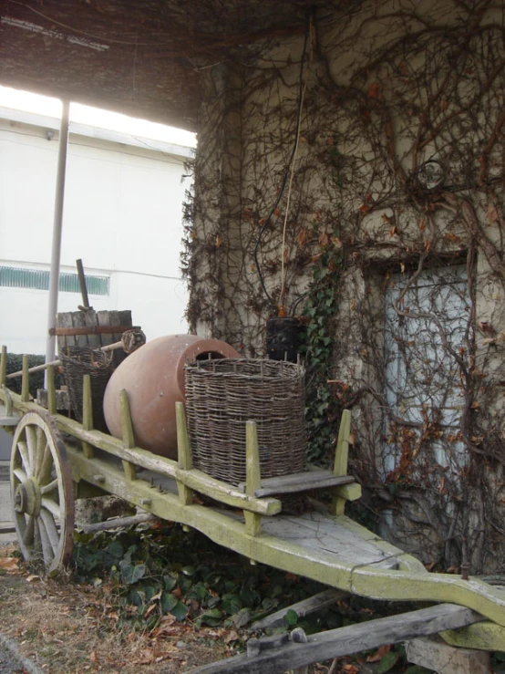 a small wooden cart with two large pots on the back