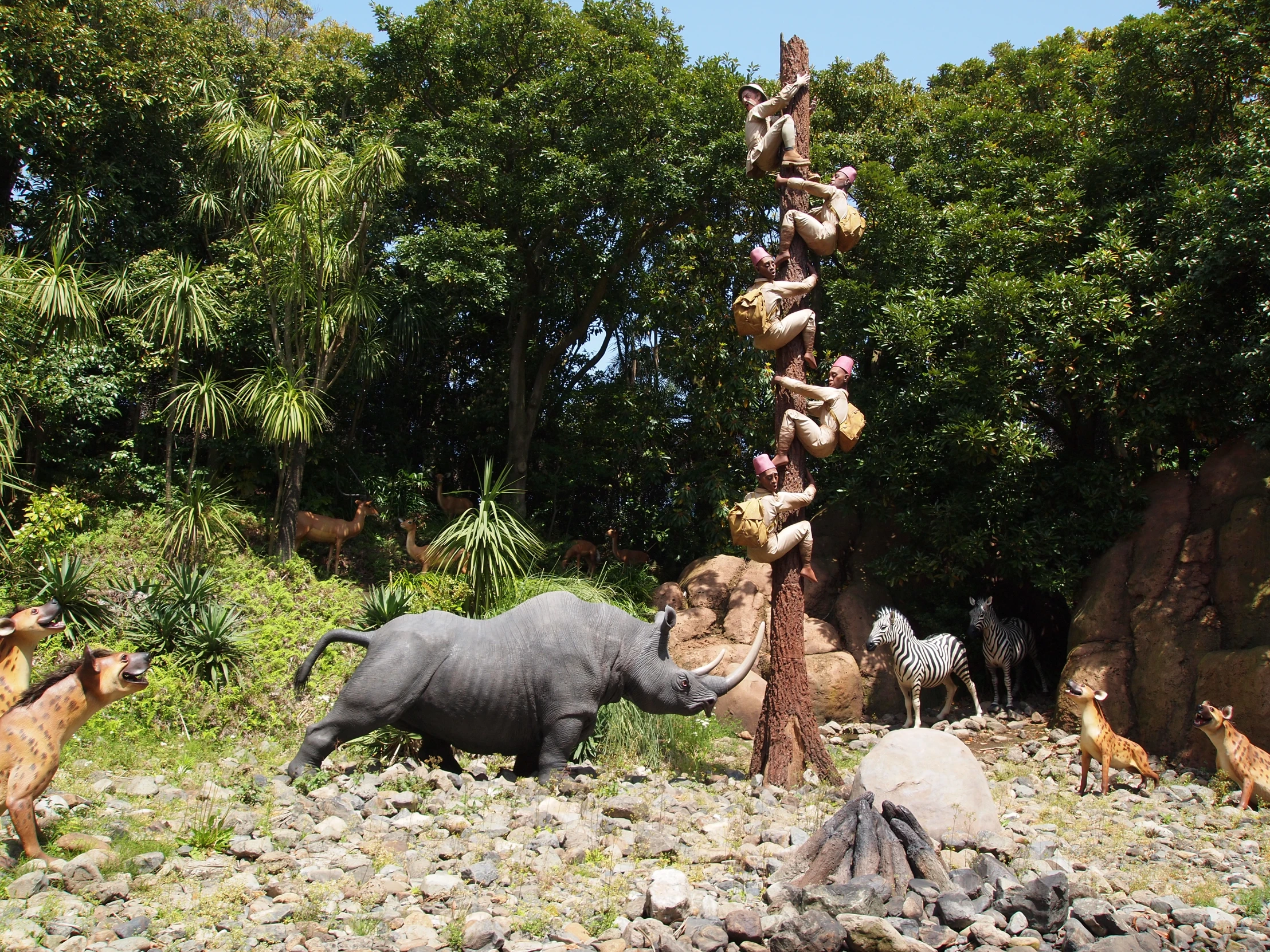 animals on the rocks beside the tall pole