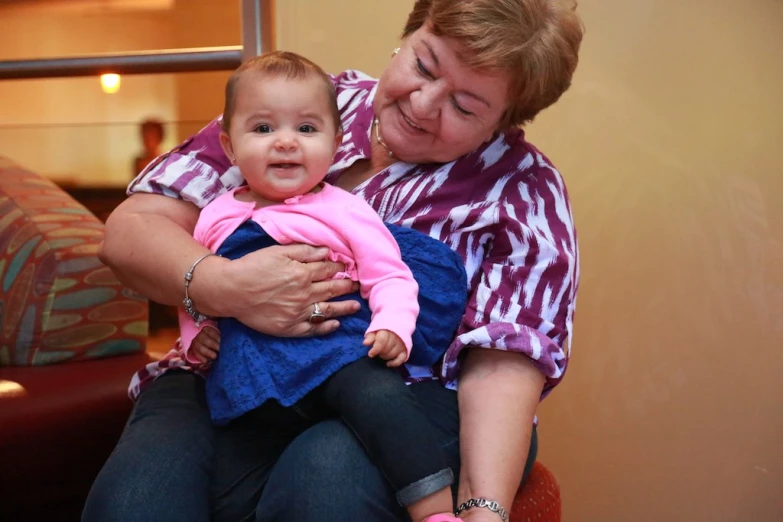 woman is hugging her baby girl while she smiles