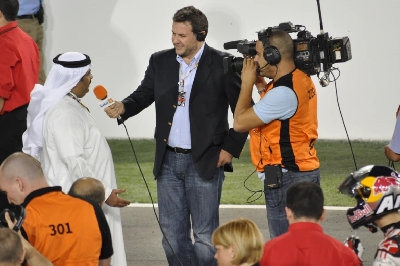 a man in white and orange clothes is being interviewed