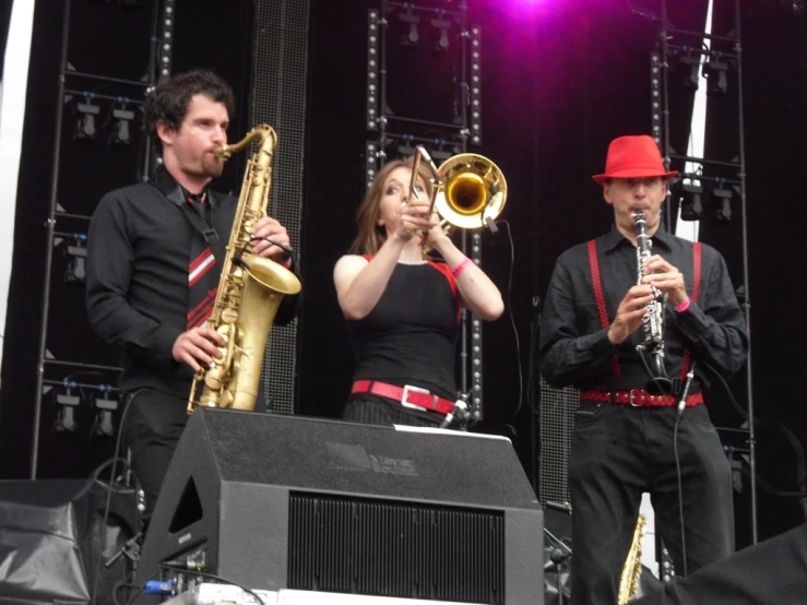 several people wearing black playing instruments in the crowd