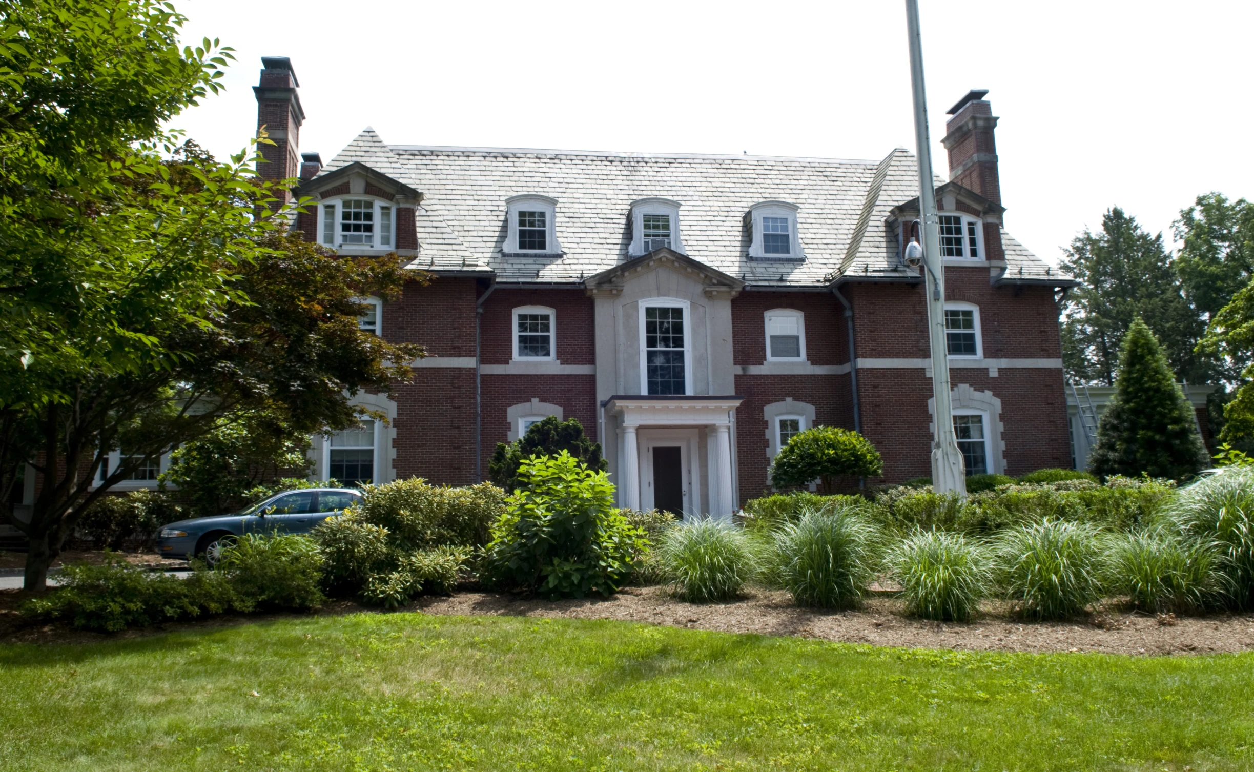 the building has a large lawn and trees outside