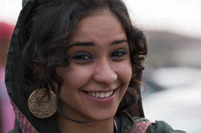 a smiling  wearing large wooden earrings