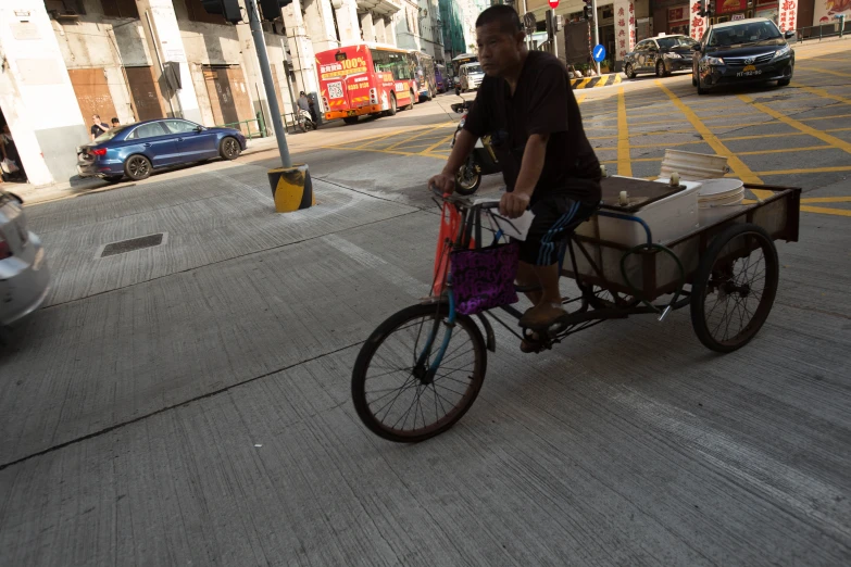 a man riding a bike in a city with his basket strapped to the front of the bicycle