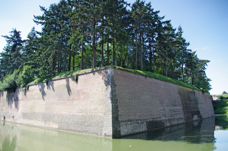 a concrete wall by the side of a lake