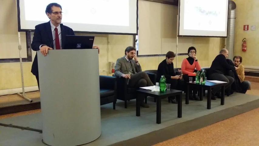 a man speaking on stage at a seminar