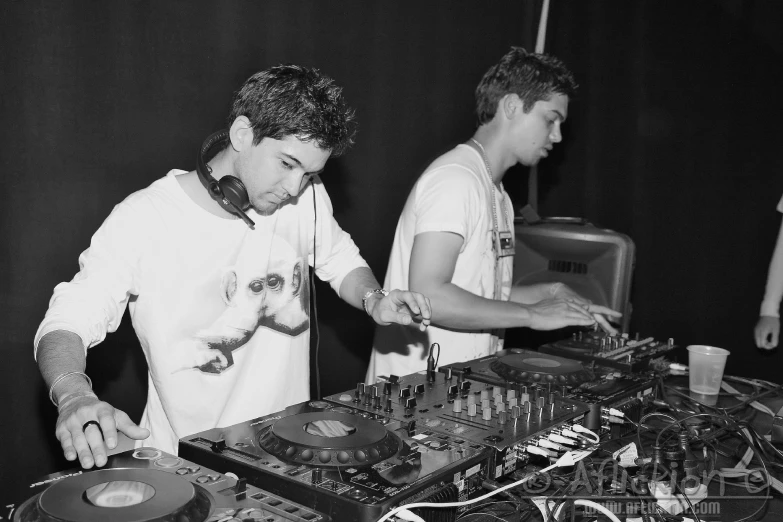 a pair of men that are in front of sound equipment