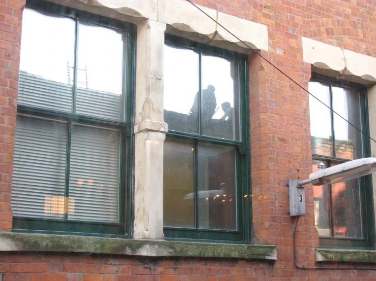 three windows and a security box on the side of a building