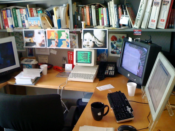 a computer desk with three monitors and a keyboard